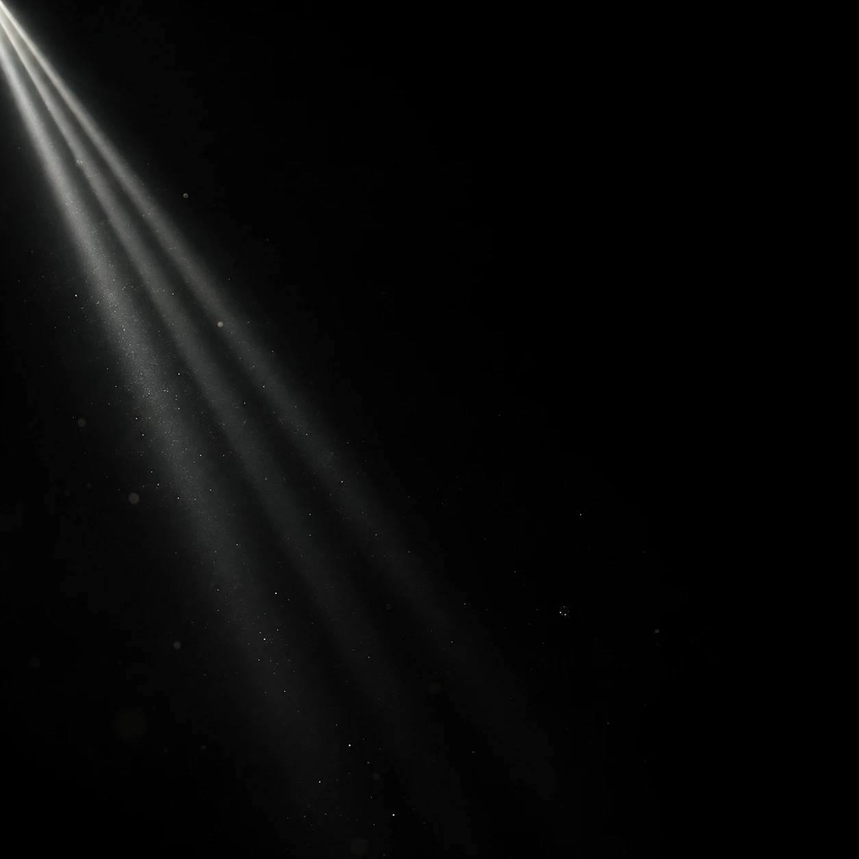 Three very narrow parallel white light rays enter from the upper left, fade quickly into black, sparse tiny drifting dust.