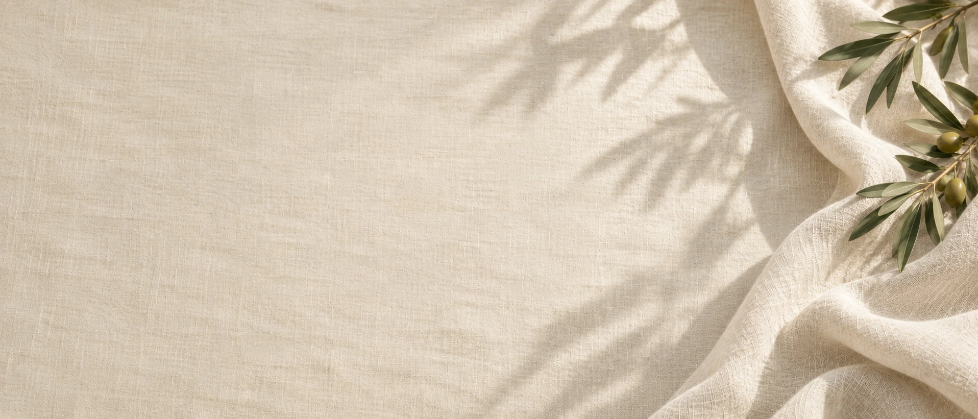 Soft linen folds and gentle olive morning light. Alternate hero with copy on left.