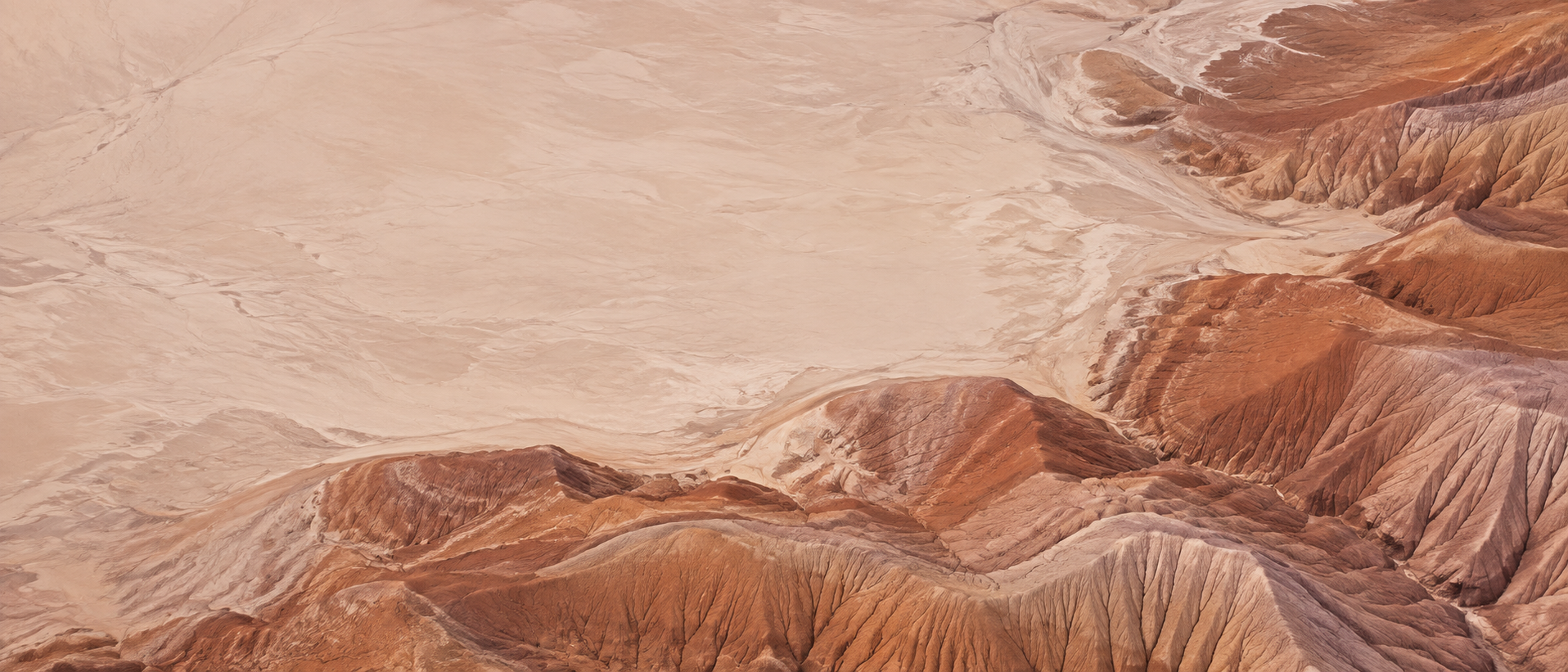 Sculpted desert lines and warm terracotta earth. Main background.
